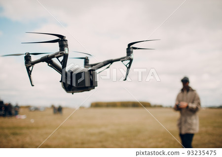 Man controlling fpv quadcopter drone for aerial photography and videography with goggles antenna remote controller. Man controlling fpv quadcopter drone for aerial photography and videography with goggles antenna remote controller. 93235475