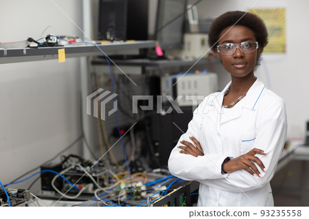 Scientist african american woman standing and looking at camera in laboratory with electronic tech instruments. Research and development of electronic devices by color black woman. 93235558