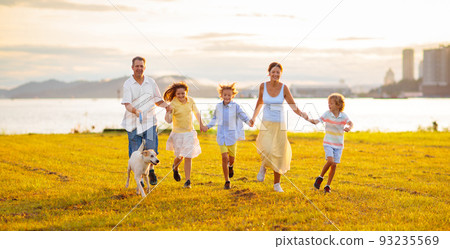 Family with kids running outdoor at sunset. 93235569