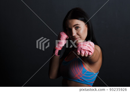 Sportsman muay thai woman boxer posing in training studio Sportsman muay thai woman boxer posing in training studio 93235926