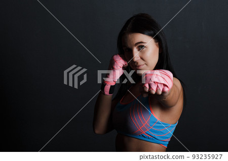 Sportsman muay thai woman boxer posing in training studio 93235927