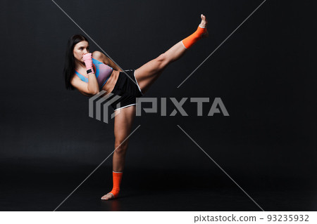 Sportsman muay thai woman boxer posing in training studio 93235932