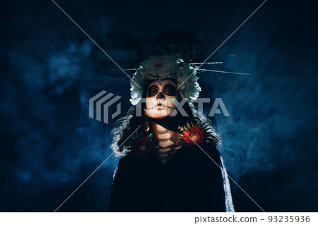 Woman with mexican skull halloween makeup on face. Day of the dead aka Dia de los Muertos and halloween party concept. Woman with mexican skull halloween makeup on face. Day of the dead aka Dia de los Muertos and halloween party concept. 93235936