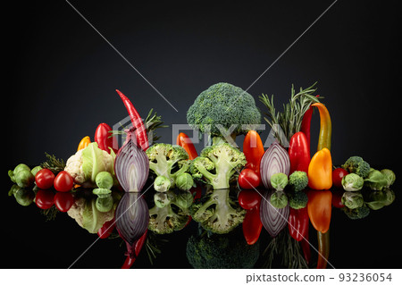 Various raw vegetables on a black reflective background. Various raw vegetables on a black reflective background. 93236054