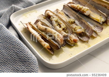 Coked Ensis Clams with garlic and herbs on plate. Typical dish of galician cuisine 93236409
