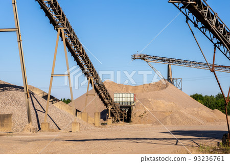 Panoramic view heavy metal construction open pit gravel plant sand quarry big rusty rotor machine material excavating and crushing on blue sky. Industrial machinery factory equipment steel background Panoramic view heavy metal construction open pit gravel plant sand quarry big rusty rotor machine material excavating and crushing on blue sky. Industrial machinery factory equipment steel background 93236761