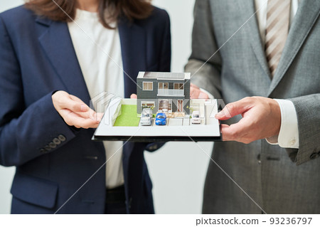 Men and women in suits with elaborate house models 93236797