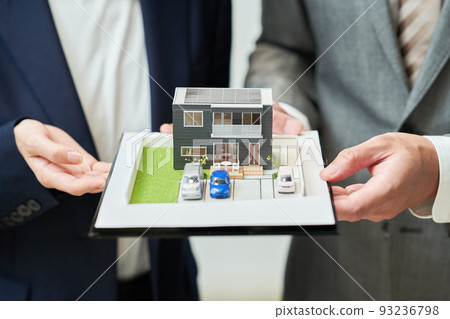 Men and women in suits with elaborate house models Men and women in suits with elaborate house models 93236798