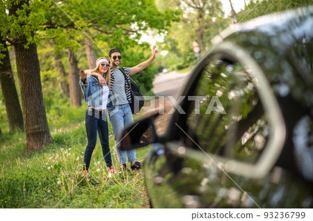 Two people trying to stop the car in the forest and looking joyful Two people trying to stop the car in the forest and looking joyful 93236799