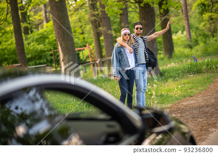 Two people trying to stop the car in the forest and looking joyful Two people trying to stop the car in the forest and looking joyful 93236800