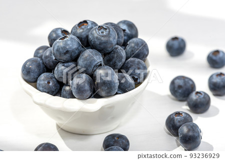 Freshly picked blueberries in a white vintage ceramic bowl. Selective focus. 93236929