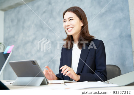 微笑著做辦公桌工作的女商人 微笑著做辦公桌工作的女商人 93237212