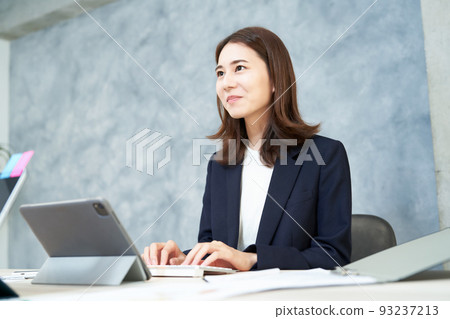 微笑著做辦公桌工作的女商人 微笑著做辦公桌工作的女商人 93237213