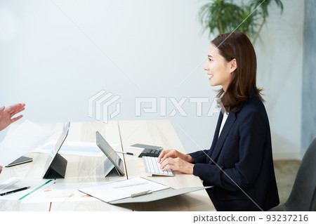微笑著做辦公桌工作的女商人 微笑著做辦公桌工作的女商人 93237216