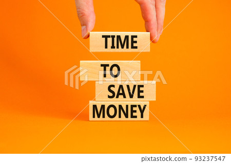 Time to save money symbol. Concept words Time to save money on wooden blocks on a beautiful orange table orange background. Businessman hand. Business, finacial and time to save money concept. Time to save money symbol. Concept words Time to save money on wooden blocks on a beautiful orange table orange background. Businessman hand. Business, finacial and time to save money concept. 93237547