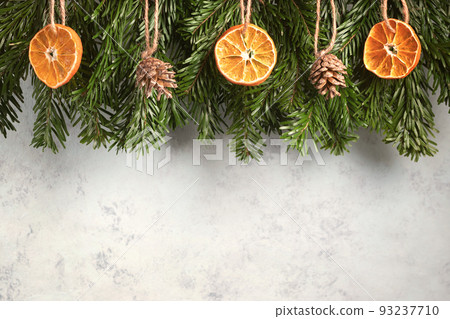 Zero waste and eco friendly christmas concept. Christmas tree branches with natural decorations on a gray wall. Horizontal banner with copy space Zero waste and eco friendly christmas concept. Christmas tree branches with natural decorations on a gray wall. Horizontal banner with copy space 93237710