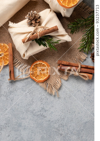 Zero waste christmas concept. Packed in natural fabric gifts and decorations from natural materials on gray table, top view, copy space Zero waste christmas concept. Packed in natural fabric gifts and decorations from natural materials on gray table, top view, copy space 93237713