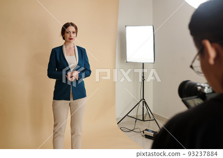 Young woman in evening wear posing for fashion catalog in studio Young woman in evening wear posing for fashion catalog in studio 93237884