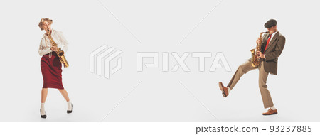 Portrait of young stylish man and woman playing trumpet at retro party isolated over white studio background Portrait of young stylish man and woman playing trumpet at retro party isolated over white studio background 93237885