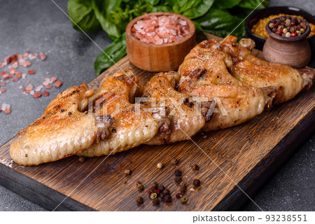Baked chicken wings with sesame seeds and sauce on a wooden cutting board Baked chicken wings with sesame seeds and sauce on a wooden cutting board 93238551