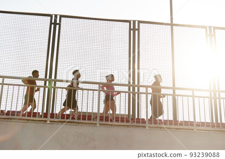 a team of young asian adult men and woman running on top of grand stand in stadium 93239088