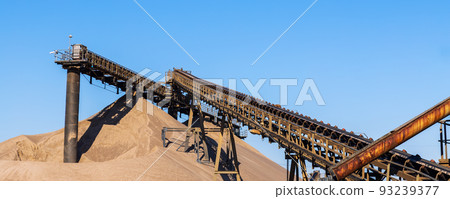 Panoramic view of heavy metal construction of open pit gravel plant sand quarry big rusty conveyor belt material excavating and crushing. Industrial machinery factory equipment steel background 93239377