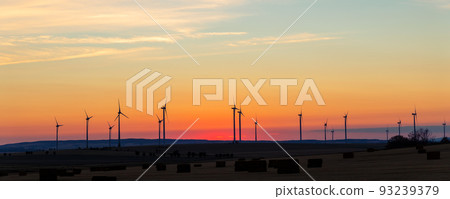 Panoramic scenic landscape view new modern wind turbine farm power generation station against fiery warm sunset sky field. Clean sustainable zero emission alternative electricity windfarm industry Panoramic scenic landscape view new modern wind turbine farm power generation station against fiery warm sunset sky field. Clean sustainable zero emission alternative electricity windfarm industry 93239379