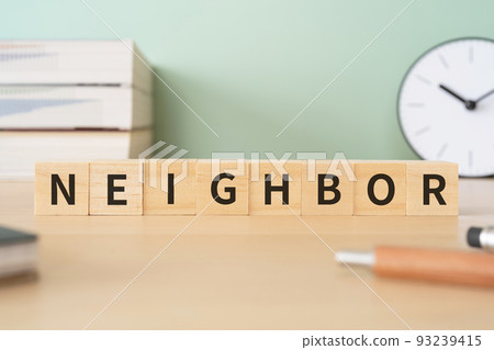 Image of neighbors/neighbours | A desk with a block written "NEIGHBOR" 93239415