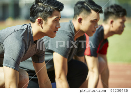 young asian track and field athletes sprinters setting on starting line 93239486
