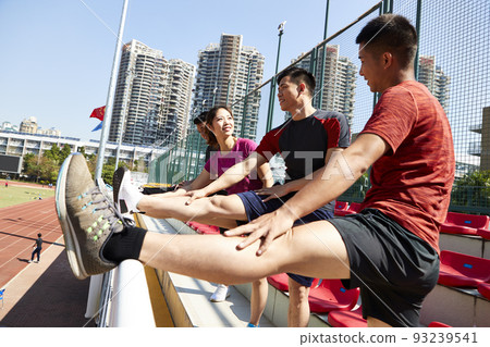 group of young asian athletes warming up pressing legs in stadium group of young asian athletes warming up pressing legs in stadium 93239541