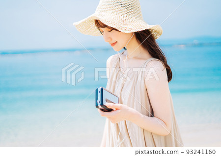 A woman listening to music by the beach 93241160