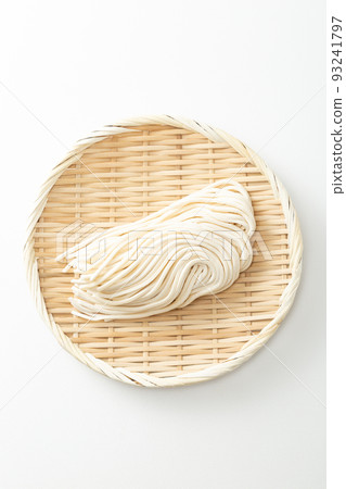 Udon in a colander, raw noodles, white background Udon in a colander, raw noodles, white background 93241797