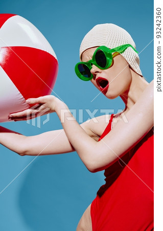 Shocked, excited swimmer with red ball for swimming looks away with her mouth open. Conceptual art of the new generation Shocked, excited swimmer with red ball for swimming looks away with her mouth open. Conceptual art of the new generation 93242360