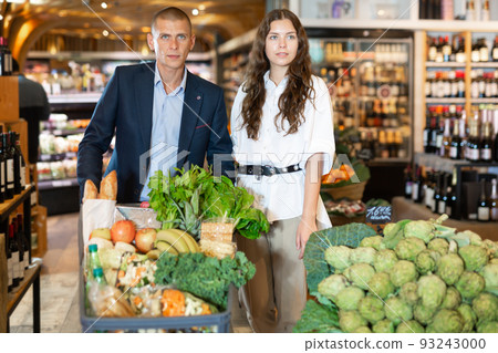 Portrait of a confident young couple with a grocery cart in the supermarket Portrait of a confident young couple with a grocery cart in the supermarket 93243000