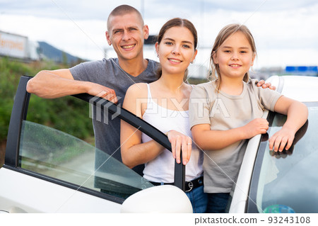 Man, woman and girl standing near car Man, woman and girl standing near car 93243108