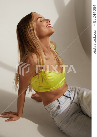 Portrait Of Laughing Woman In Fashion Clothes Sitting at Studio Portrait Of Laughing Woman In Fashion Clothes Sitting at Studio 93244084