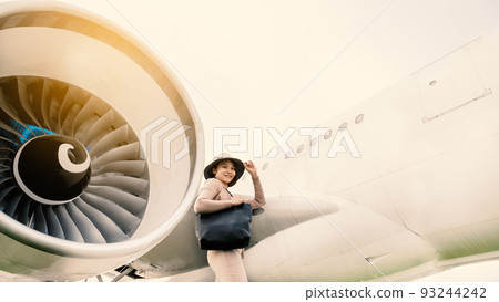Happy travel passenger Asia woman Standing in front of the plane 93244242