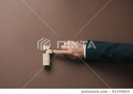 Hand of a businessman pushing a wooden cut circle into a stack of them Hand of a businessman pushing a wooden cut circle into a stack of them 93244603
