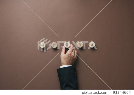 Businessman positioning wooden cut circles with contact and communication symbols on them in a row Businessman positioning wooden cut circles with contact and communication symbols on them in a row 93244604