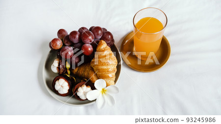 Breakfast, fruit, croissants, orange juice on a white bedsheet, Healthy food concept Breakfast, fruit, croissants, orange juice on a white bedsheet, Healthy food concept 93245986