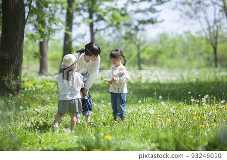 Nursery teacher and kindergarten children playing in the field 93246010
