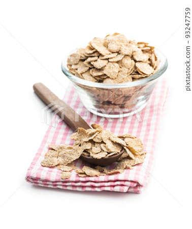 Whole grain cereal flakes in wooden spoon. Wholegrain breakfast cereals isolated on white background. Whole grain cereal flakes in wooden spoon. Wholegrain breakfast cereals isolated on white background. 93247759