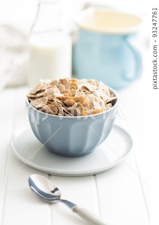 Whole grain cereal flakes. Wholegrain breakfast cereals in bowl on kitchen table. Whole grain cereal flakes. Wholegrain breakfast cereals in bowl on kitchen table. 93247761