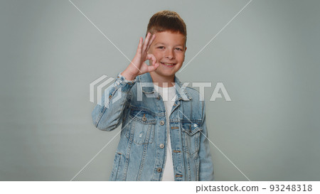 Toddler kid boy looking at camera showing ok gesture, like sign positive, approve something good Toddler kid boy looking at camera showing ok gesture, like sign positive, approve something good 93248318