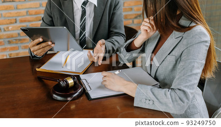 Business and lawyers discussing contract papers with brass scale on desk in office. Law, legal services, advice,  justice and law concept . 93249750