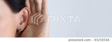 Woman held hand to ear and listened attentively. 93250588