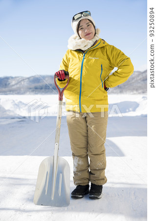 一個滿足於乾淨地鏟雪的年輕女子 93250894
