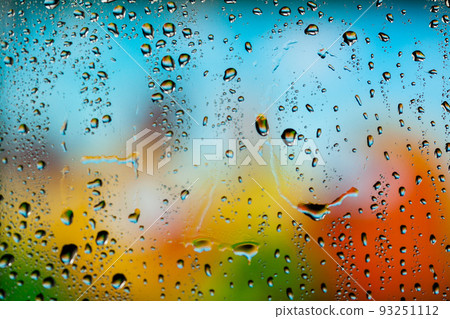 Beautiful multi-colored water droplets on a glass 93251112