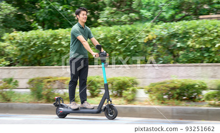 一個年輕人帶著電動踢板在城裡奔跑 93251662