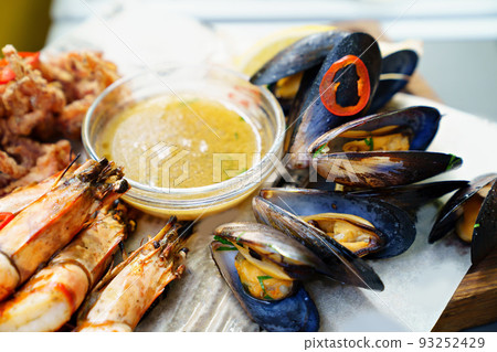 seafood. mussel and shrimp cooked on the grill with sauce and vegetables. seafood. mussel and shrimp cooked on the grill with sauce and vegetables. 93252429